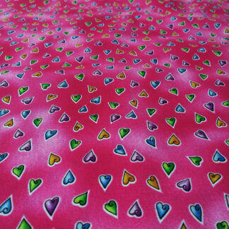 Multicoloured heart shapes on ruby print pure cotton quilting fabric - width 110 cm